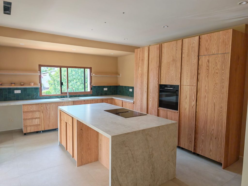 Cocina a medida en roble macizo natural con isla central fabricada por Carpintería Madermas en Denia
