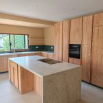 Cocina a medida en roble macizo natural con isla central fabricada por Carpintería Madermas en Denia