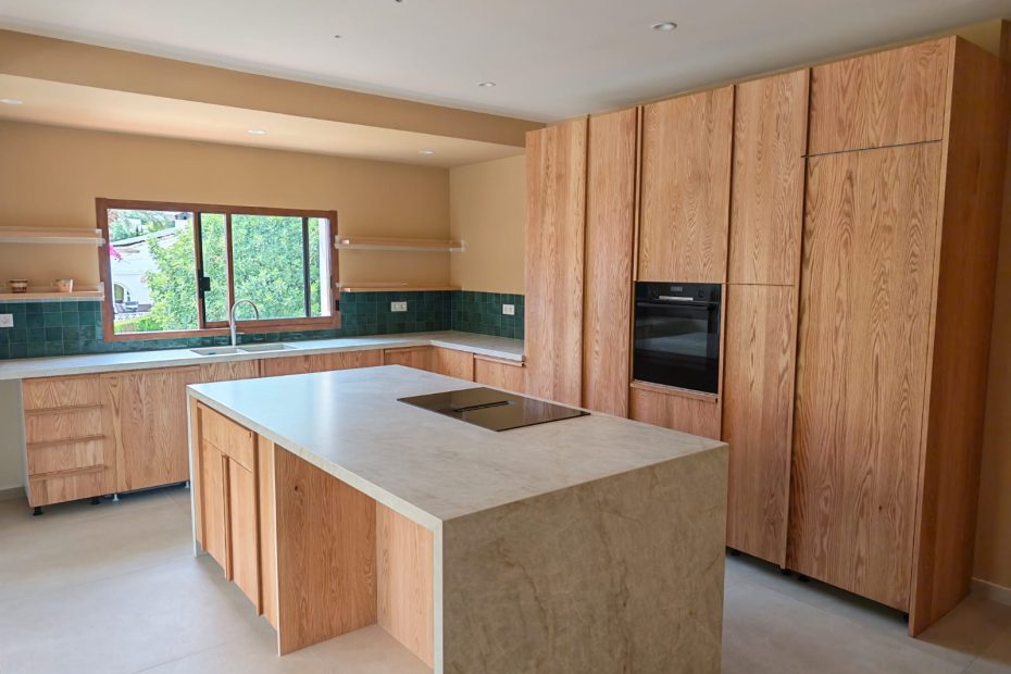 Cocina a medida en roble macizo natural con isla central fabricada por Carpintería Madermas en Denia